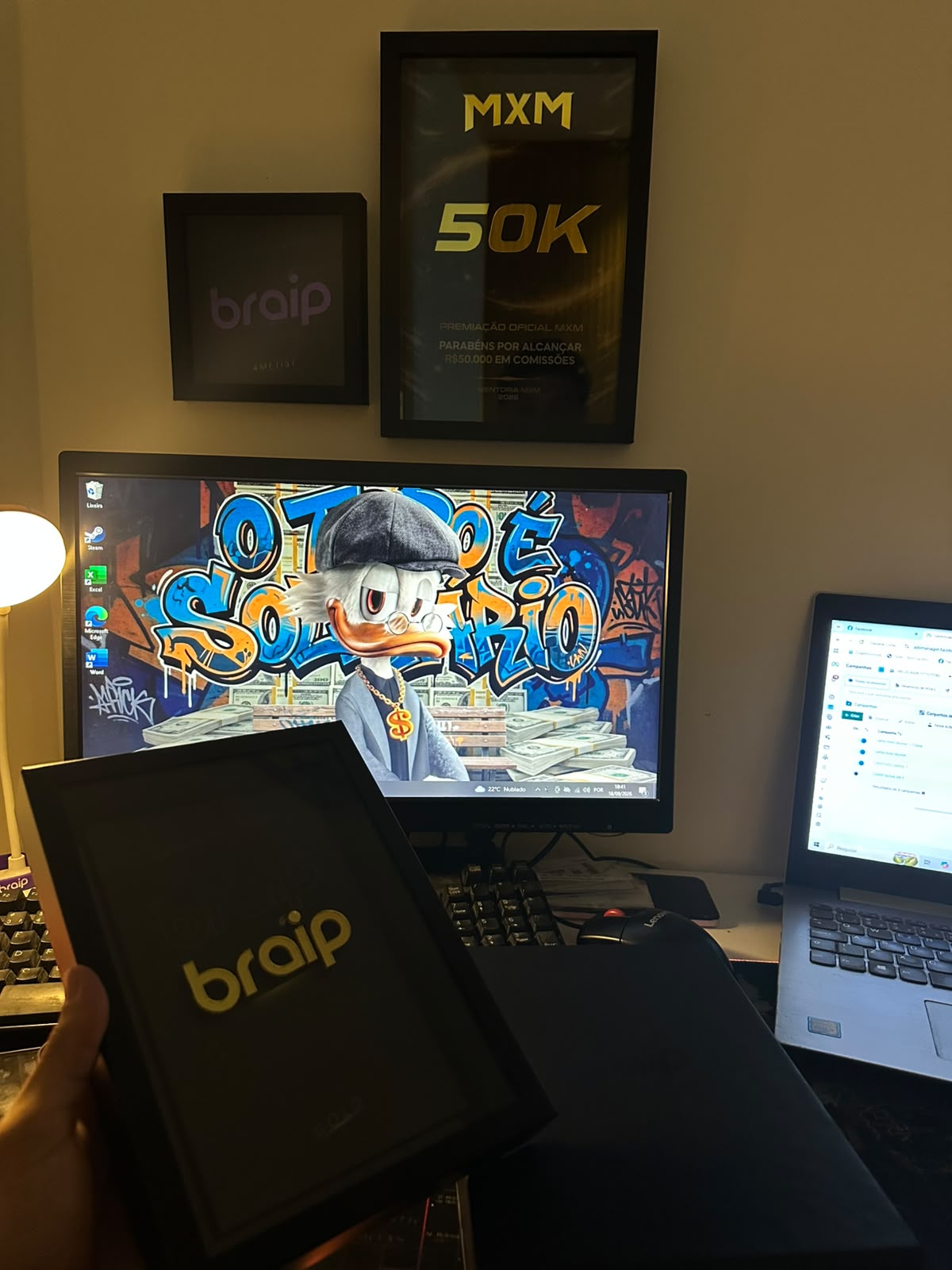 Placas de premiação da Braip e da MXM de R$ 50 mil em comissões, na parede do escritório